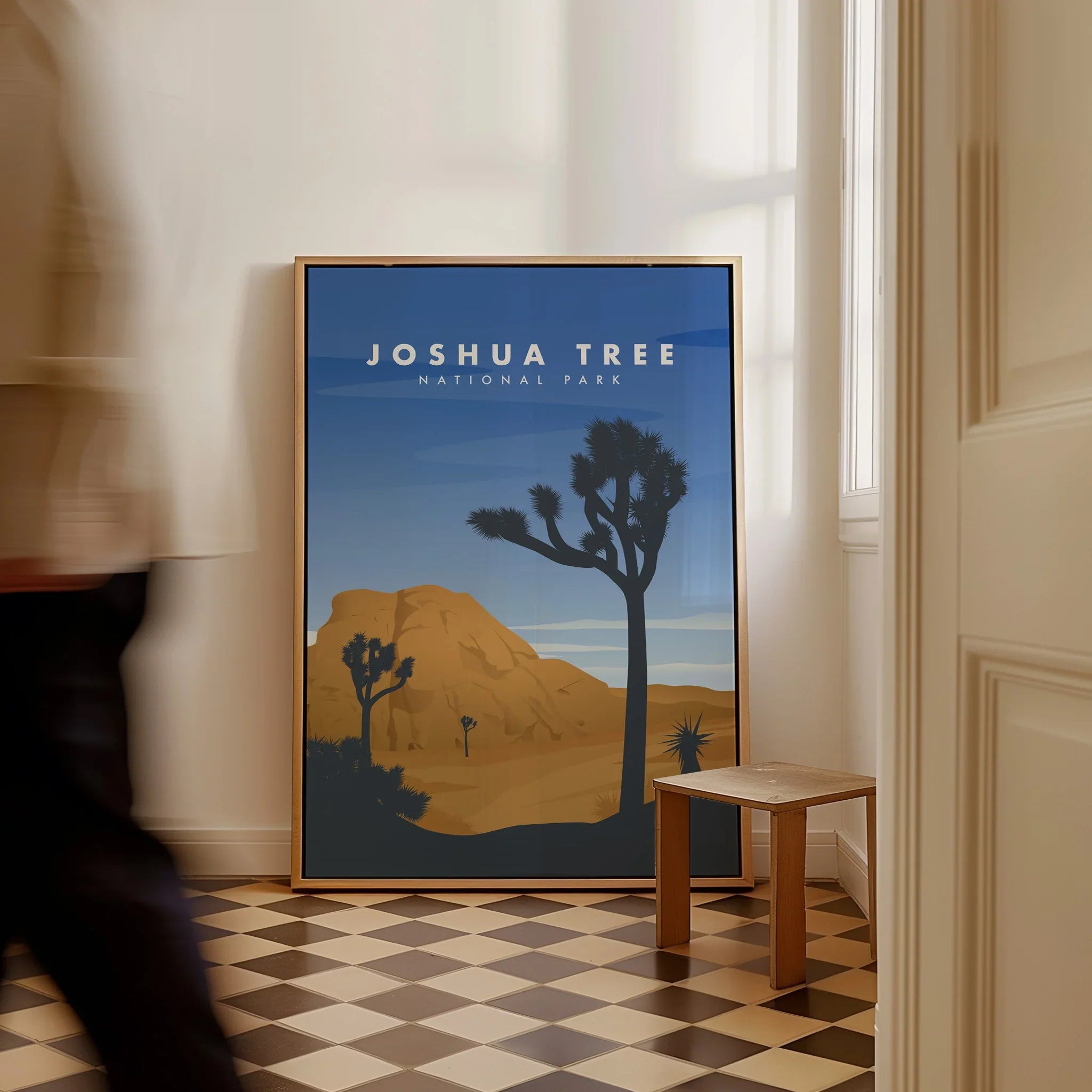 Framed Joshua Tree National Park poster with desert landscape leaning on floor in modern room