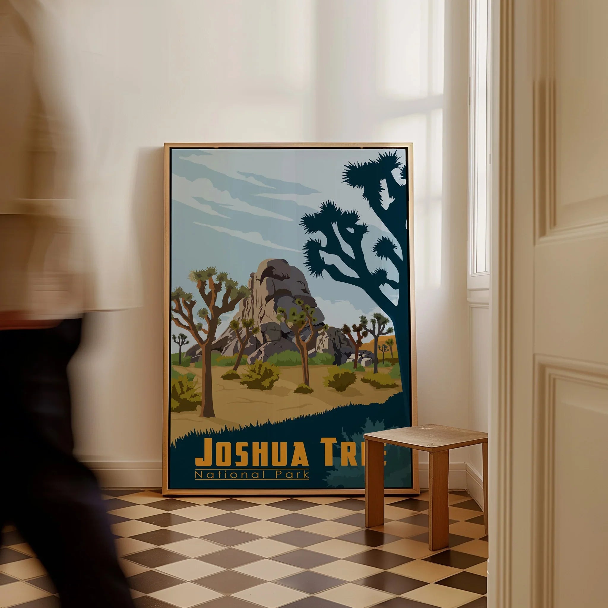 Framed Joshua Tree National Park travel poster leaning on floor in modern home entryway.