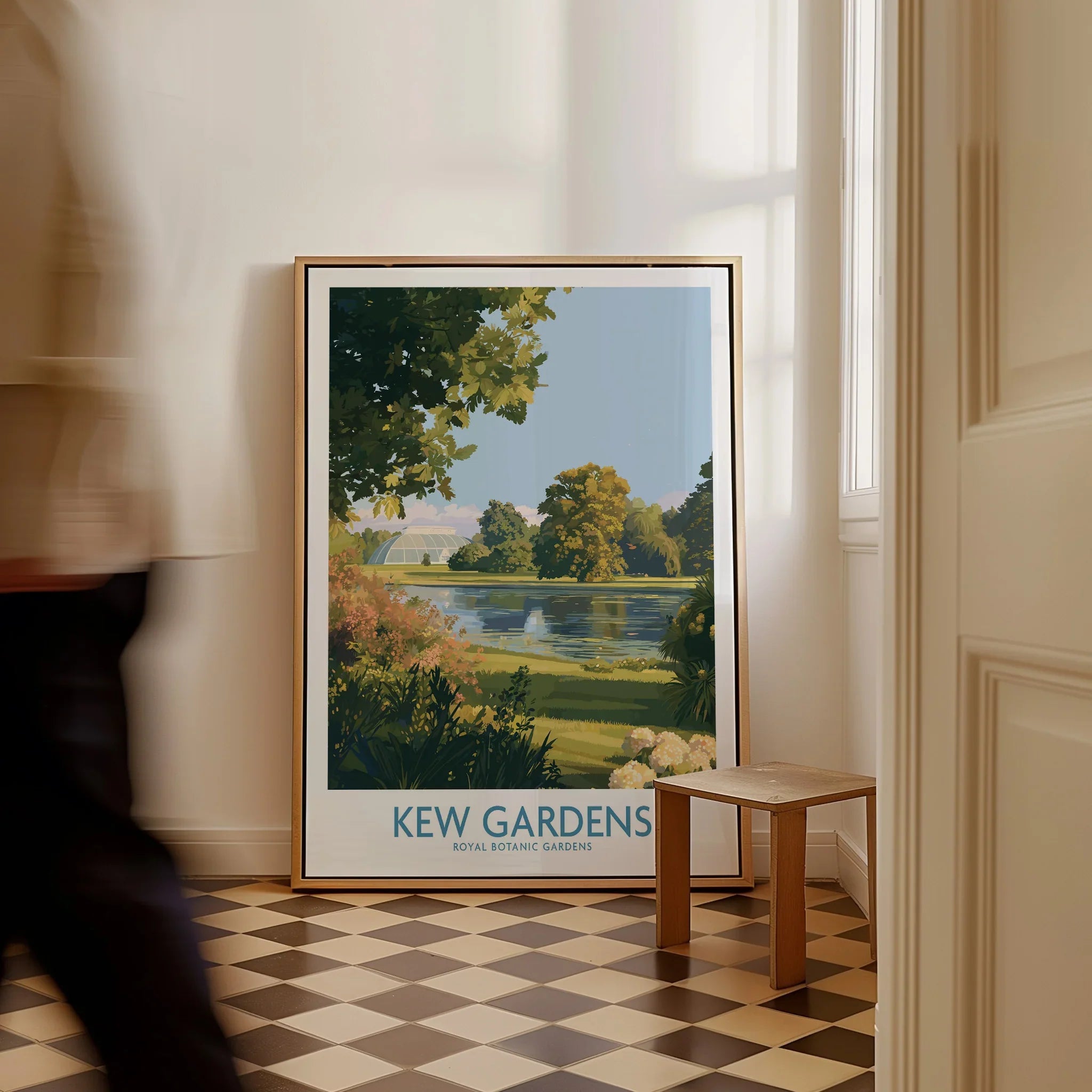 Framed Kew Gardens travel poster on floor in bright hallway, man walking past, home decor.