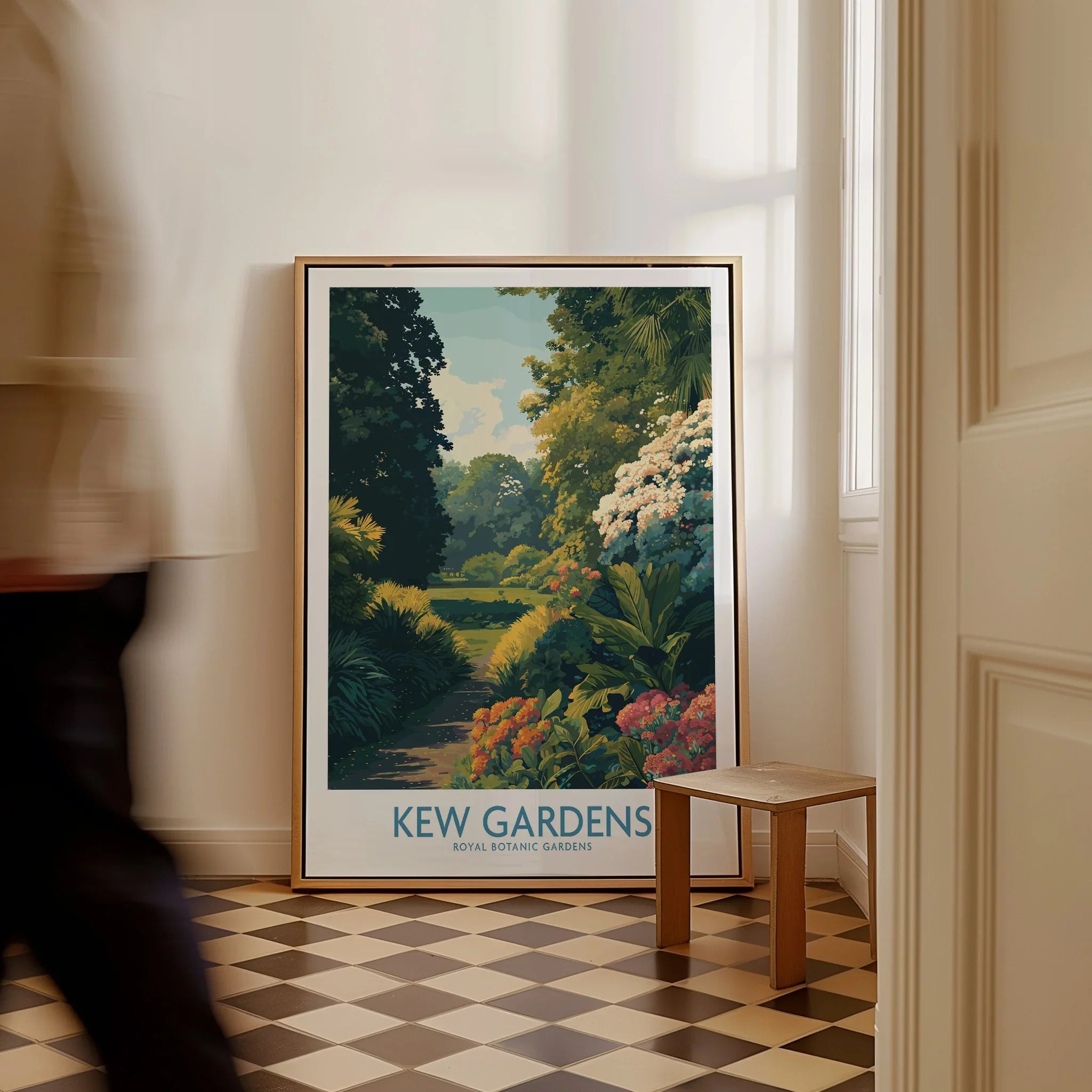 Framed Kew Gardens travel poster on checkered floor, person walking past, natural light.