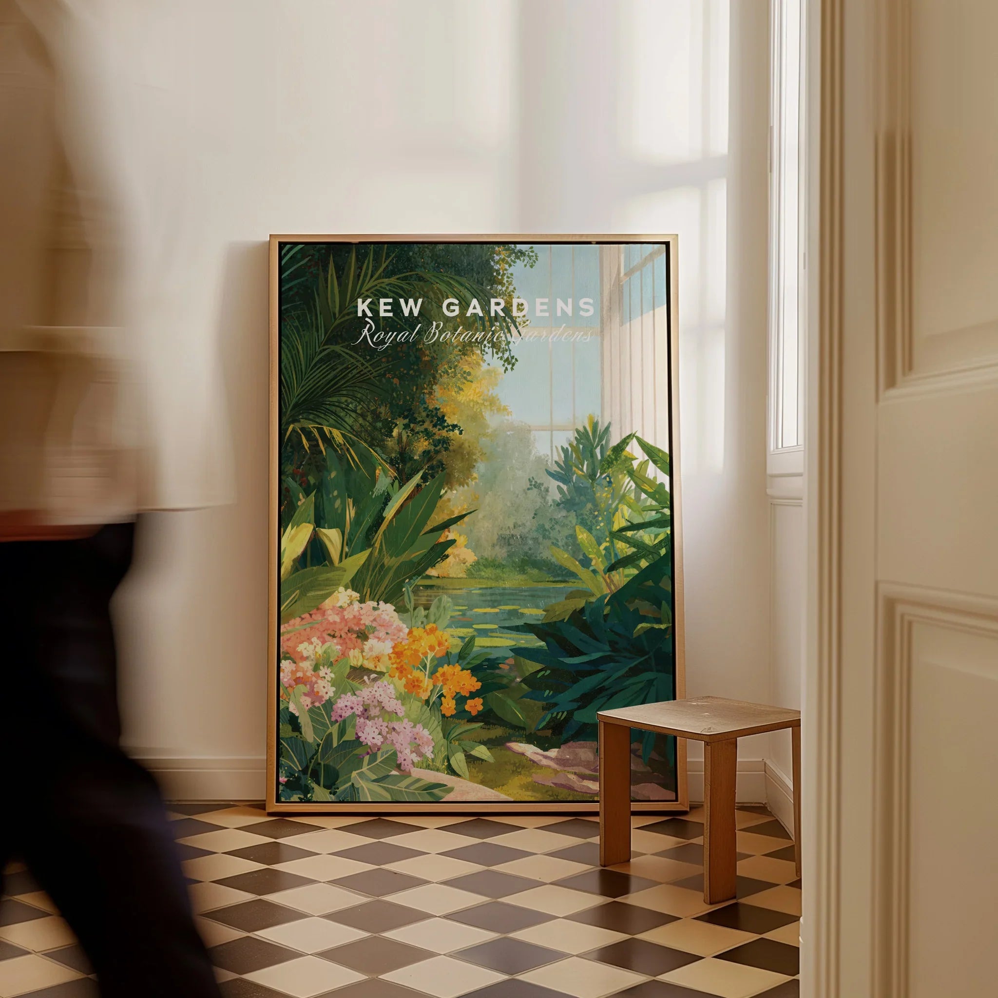 Framed Kew Gardens travel poster with lush plants on floor in sunlit hallway, man walking past