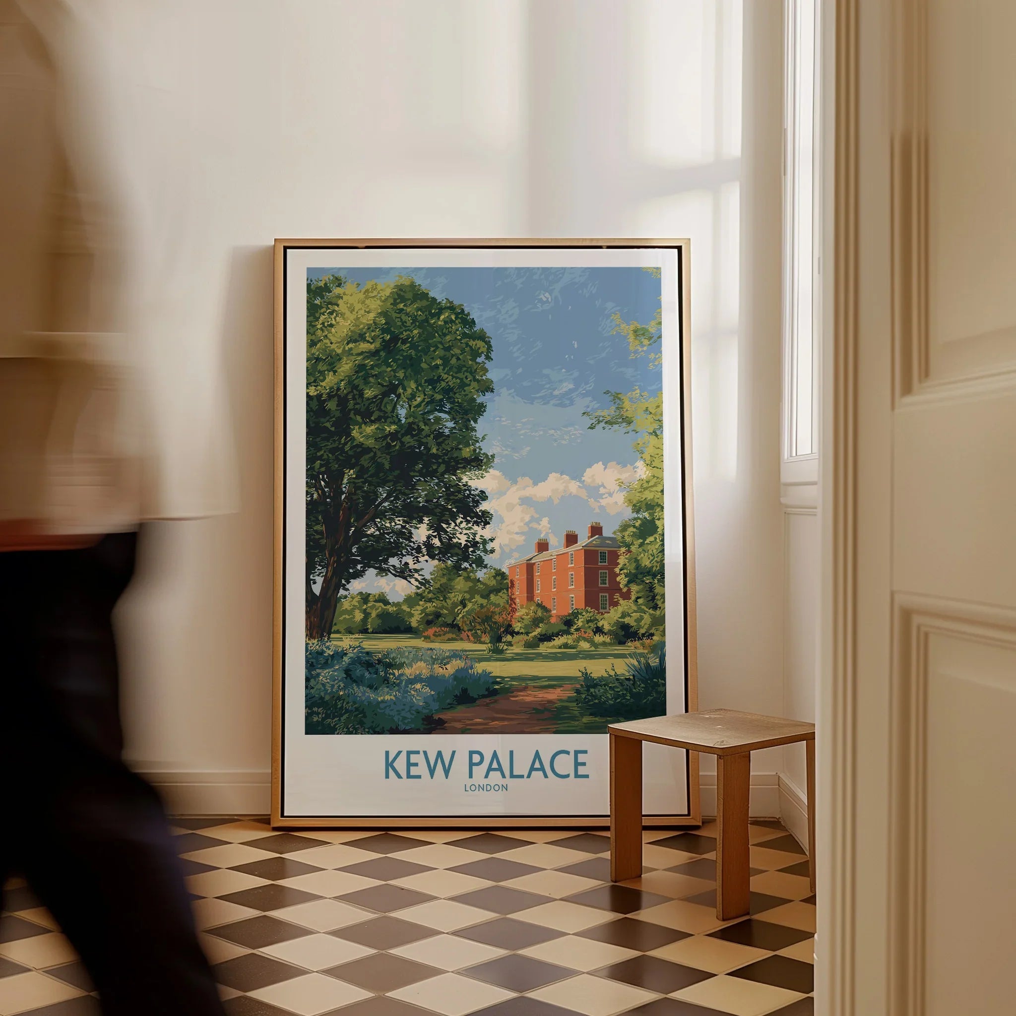 Framed Kew Palace London travel poster on floor in bright hallway with man walking past