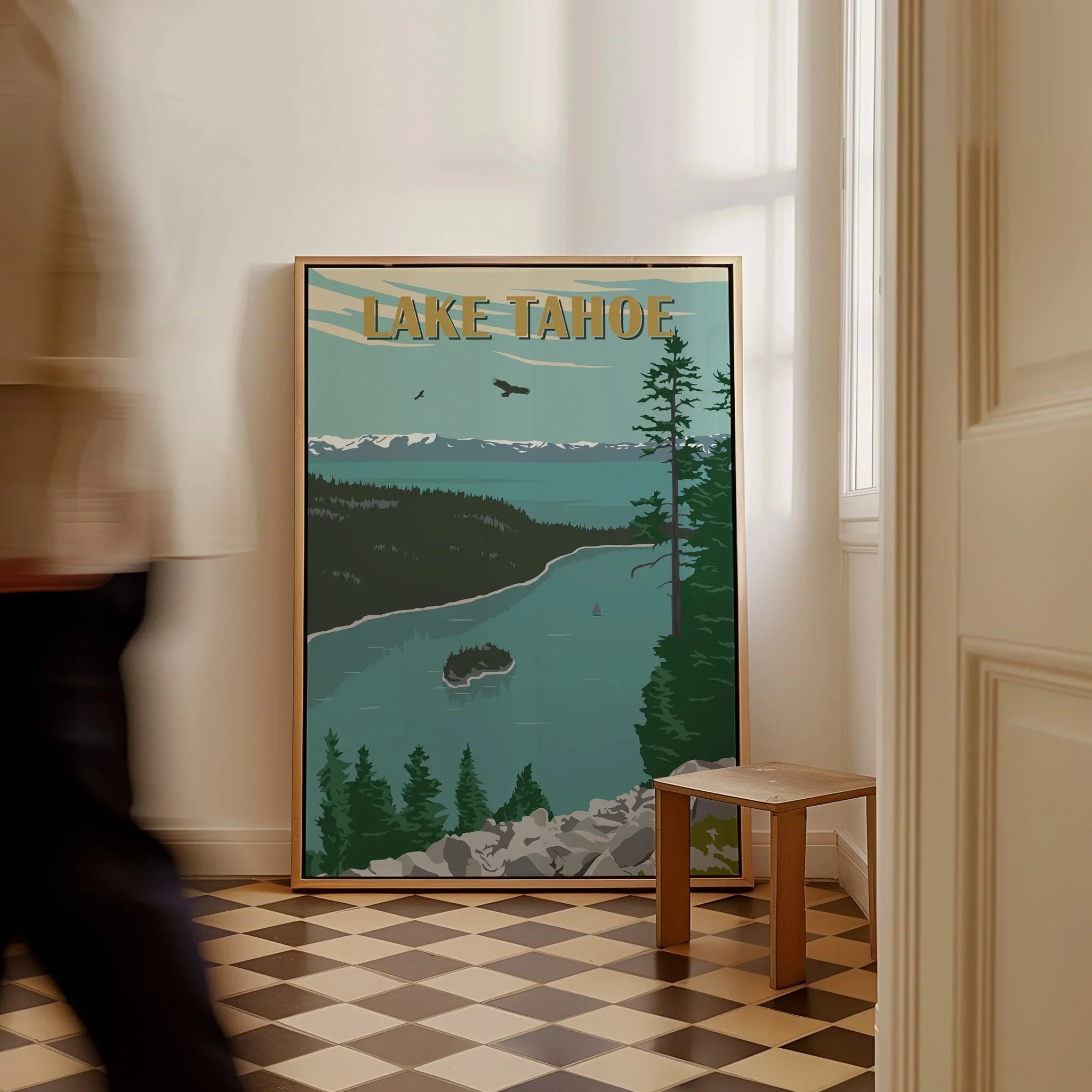 Framed Lake Tahoe travel poster with scenic mountain and lake artwork on floor in hallway