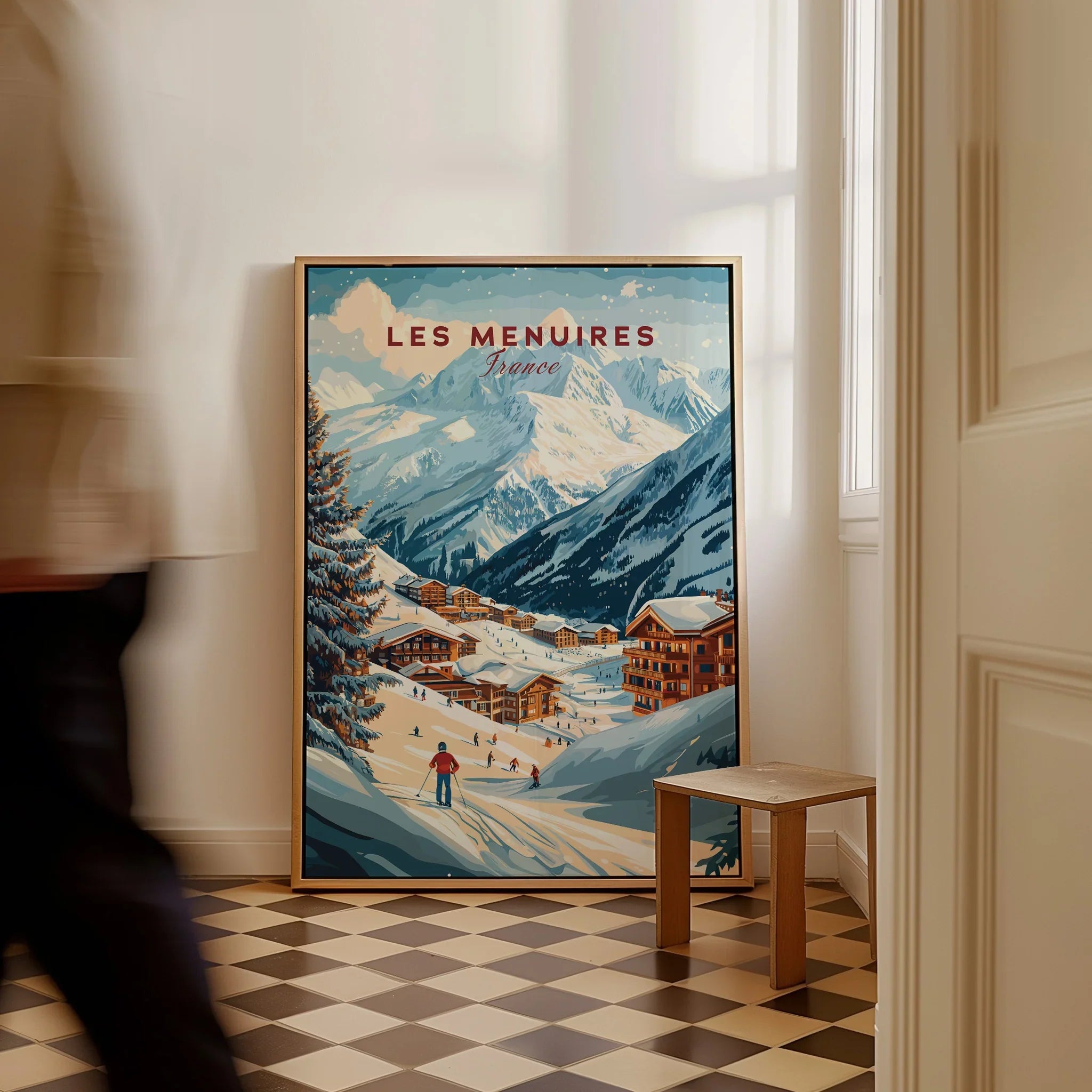 Framed Les Menuires travel poster with ski resort and mountains on floor in modern room.
