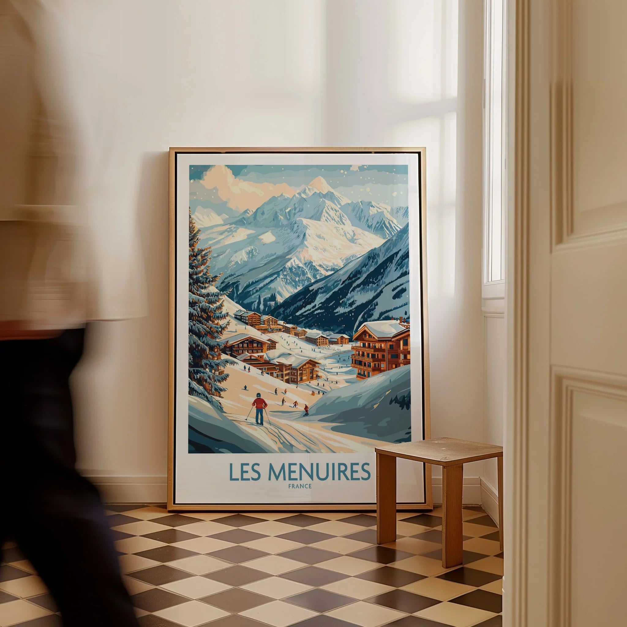 Framed Les Menuires France travel poster with snowy mountain village, leaning on floor.