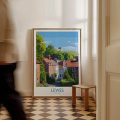 Framed Lewes England city travel poster on floor with man walking past and checkered tile