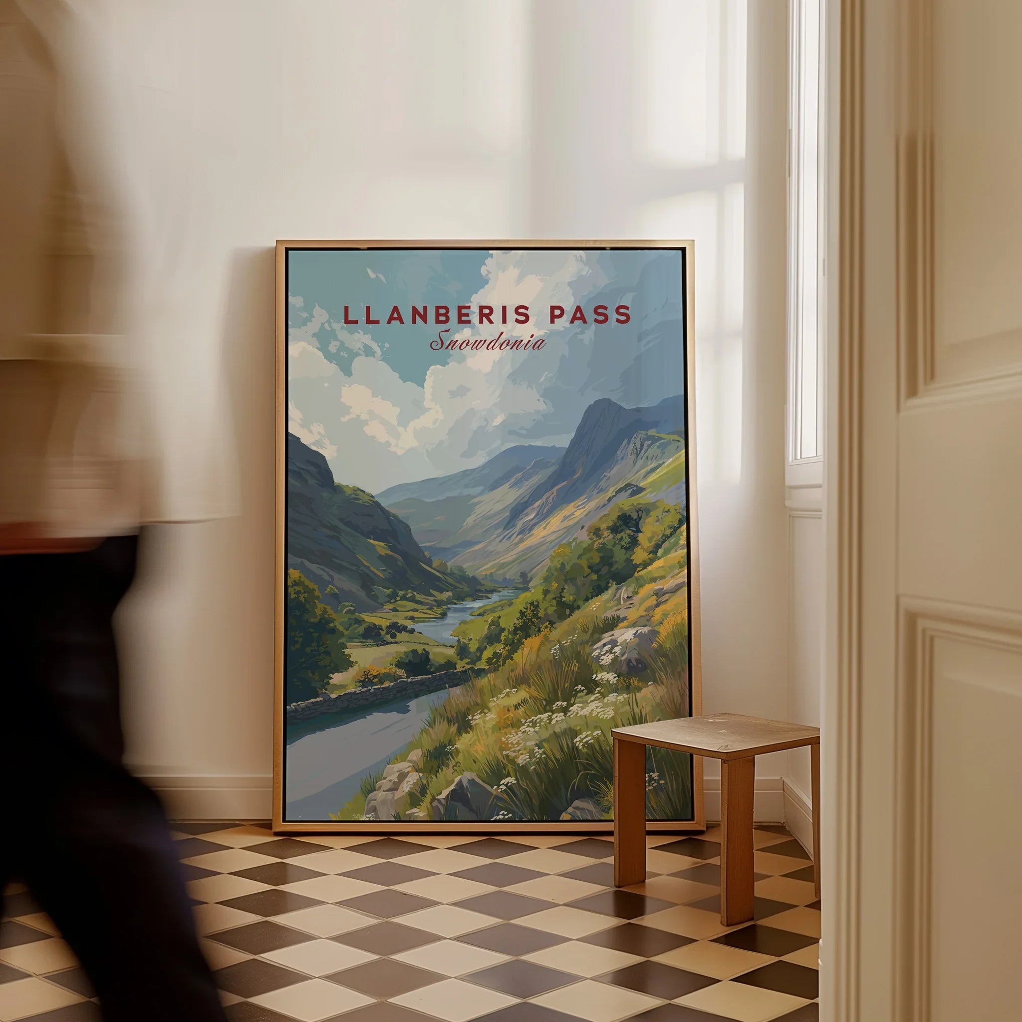Framed Llanberis Pass Snowdonia travel poster art on floor in bright hallway