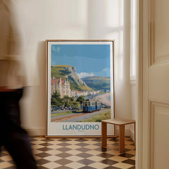 Llandudno Wales travel poster framed on floor, with tram, coastline, and scenic mountains