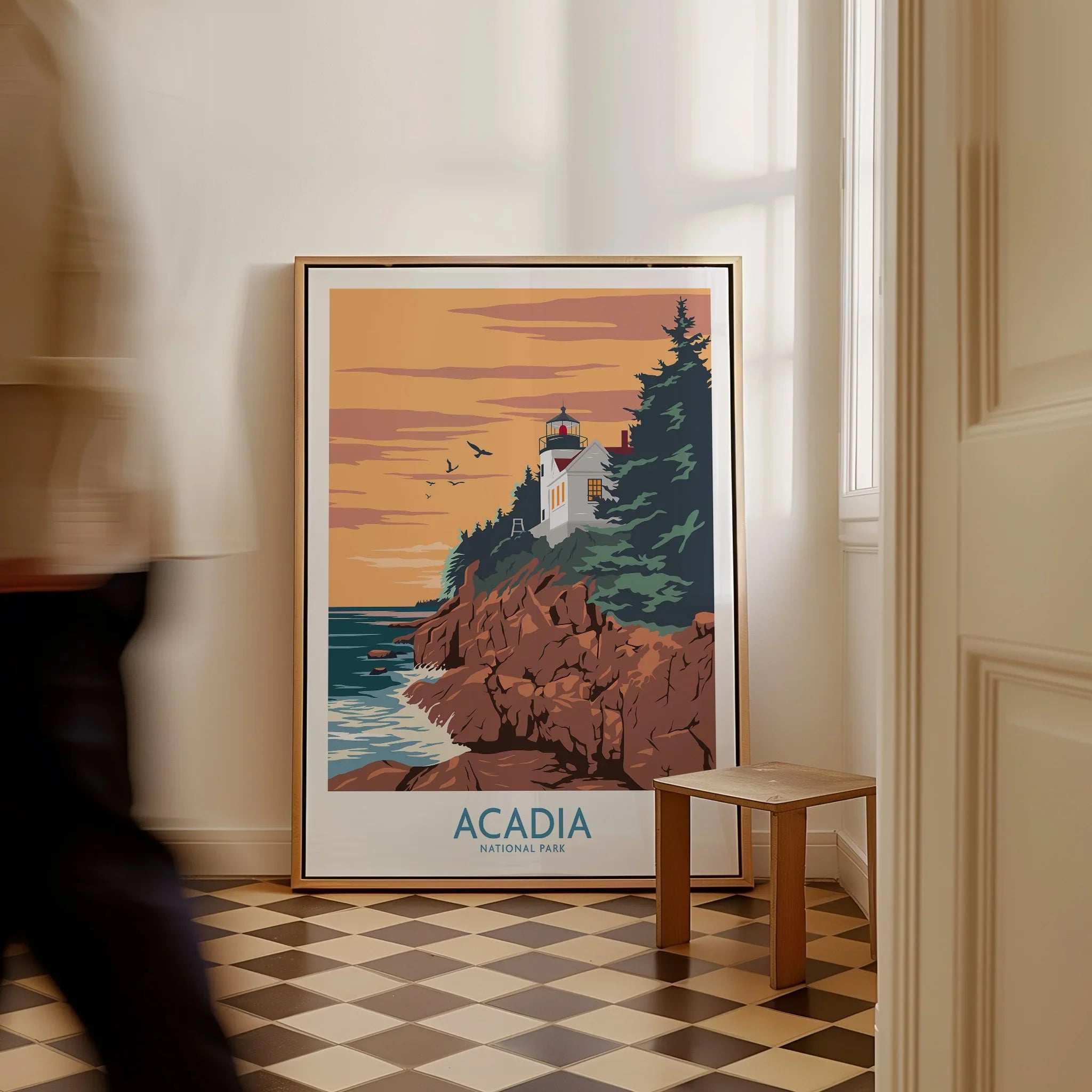 Framed Acadia National Park travel poster with lighthouse art leaning on floor in hallway