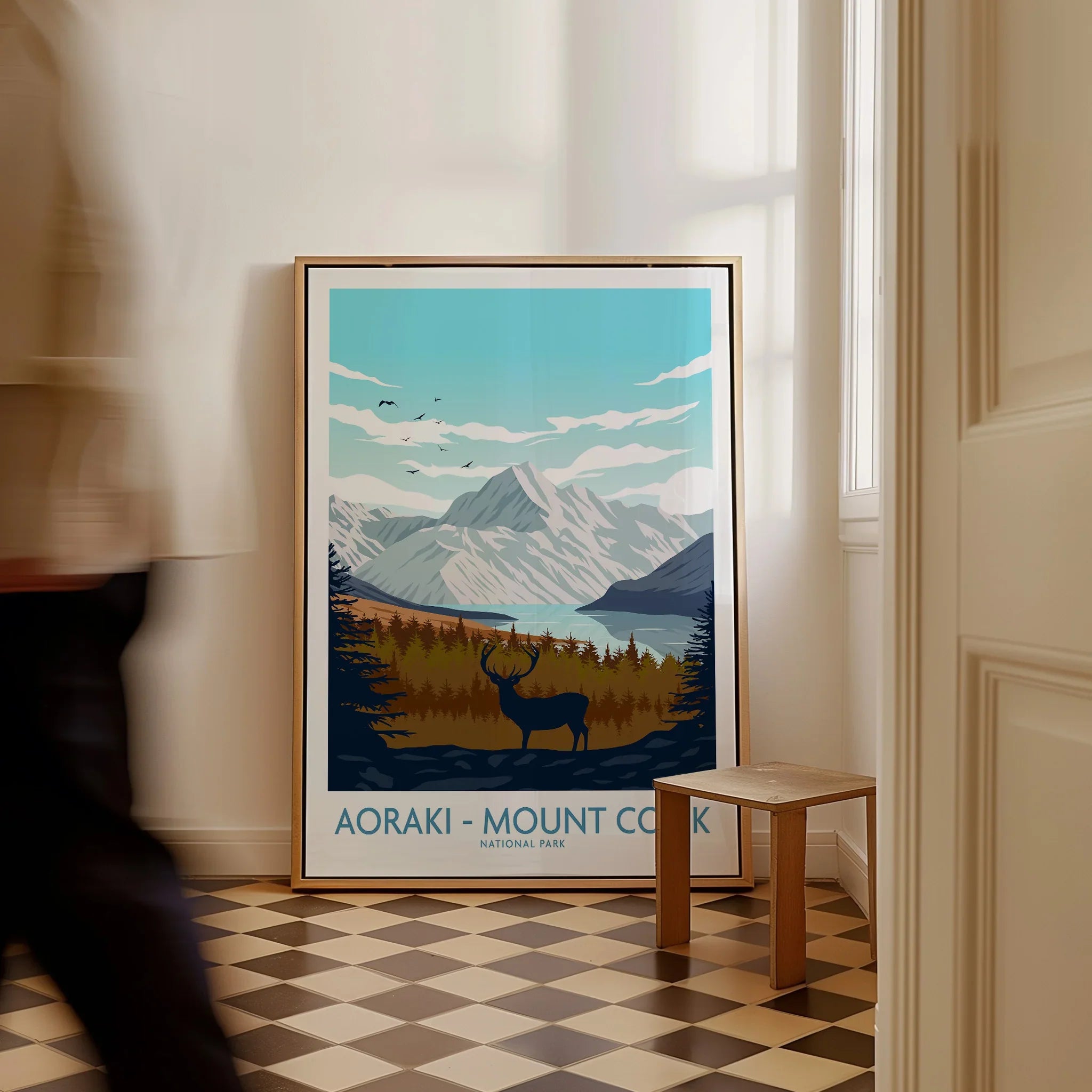 Framed Aoraki Mount Cook National Park travel poster with mountain, forest, and deer, on floor