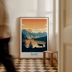 Framed Banff National Park travel poster with moose and mountains in a sunlit hallway.