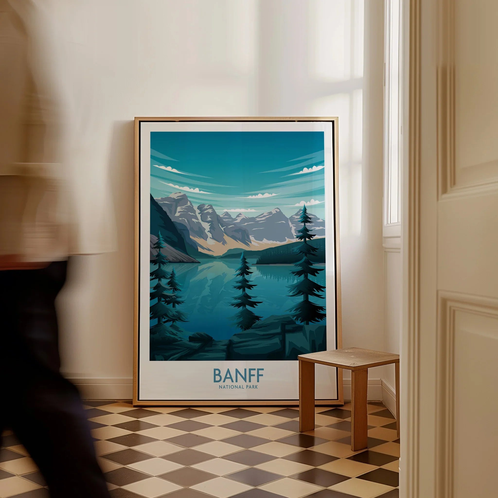Framed Banff National Park art print with mountain and lake scene on floor by window