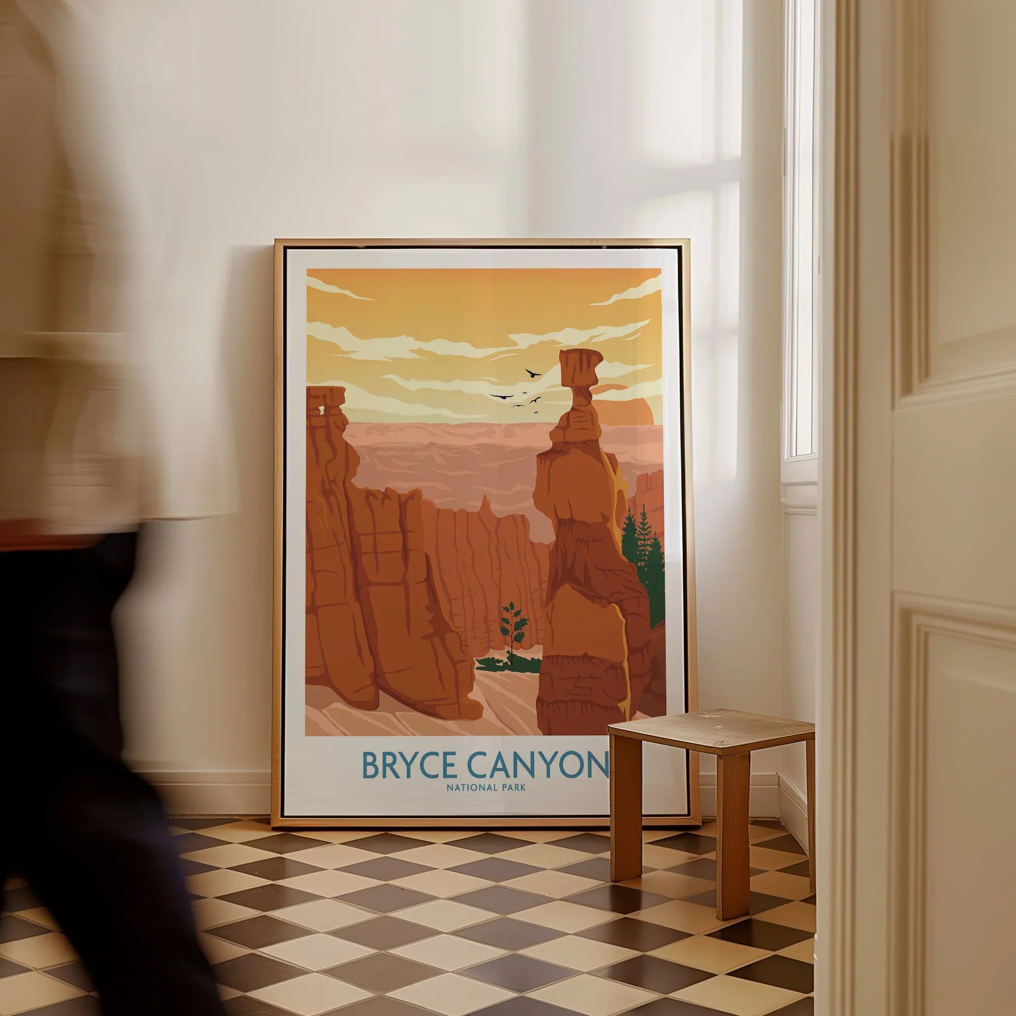 Framed Bryce Canyon National Park travel poster on floor in bright hallway with man walking by
