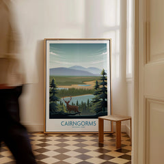 Framed Cairngorms National Park travel poster with deer and mountains, leaning on floor in bright hallway