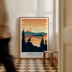 Framed Crater Lake National Park art print on floor, with silhouette deer and mountain scenery.