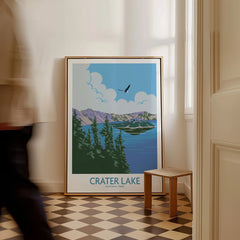 Framed Crater Lake National Park travel poster on floor in bright hallway, person walking past