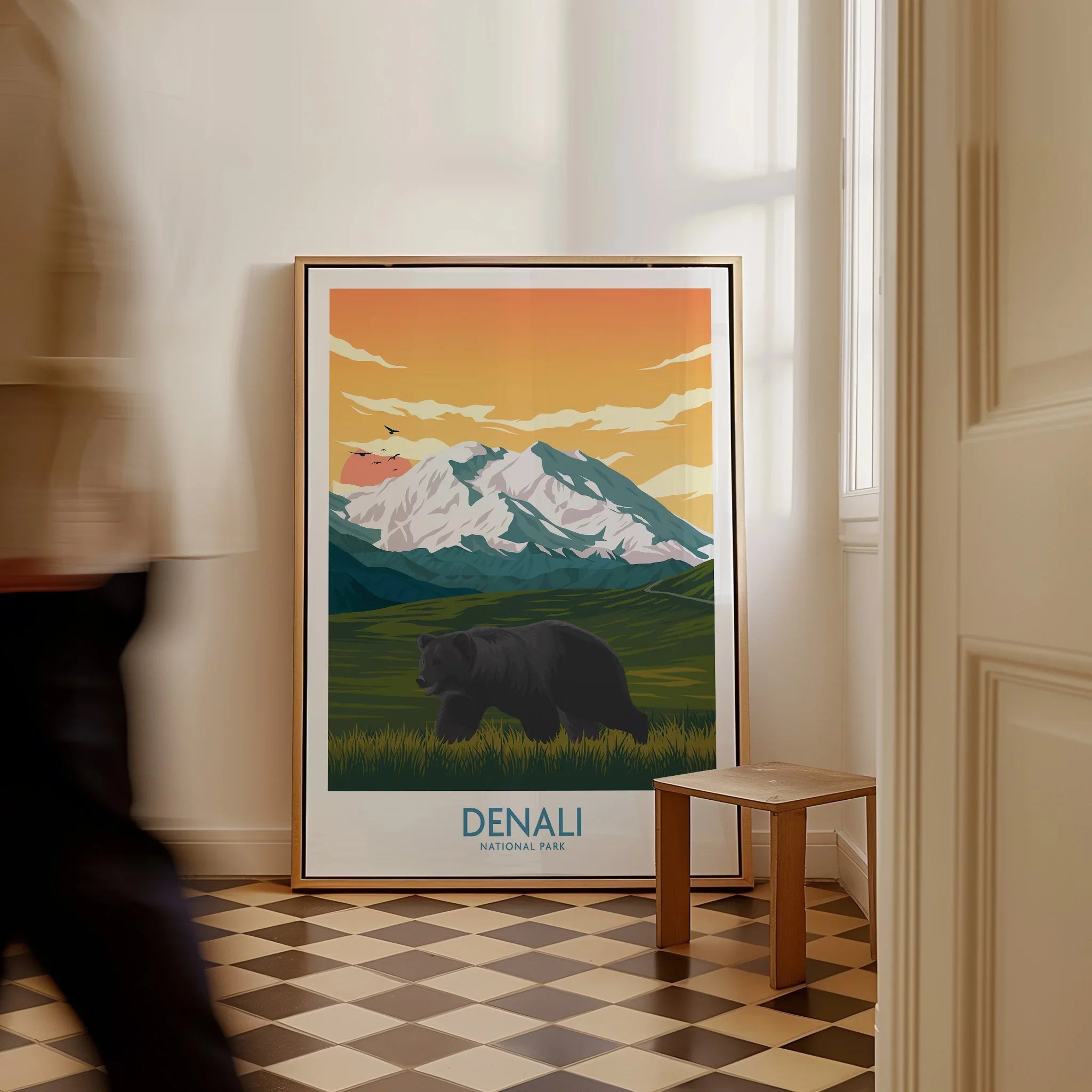 Framed Denali National Park poster with bear and mountains, leaning on wall in bright room
