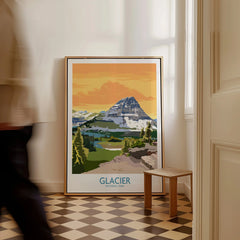 Framed Glacier National Park travel poster on floor in bright hallway, man walking past