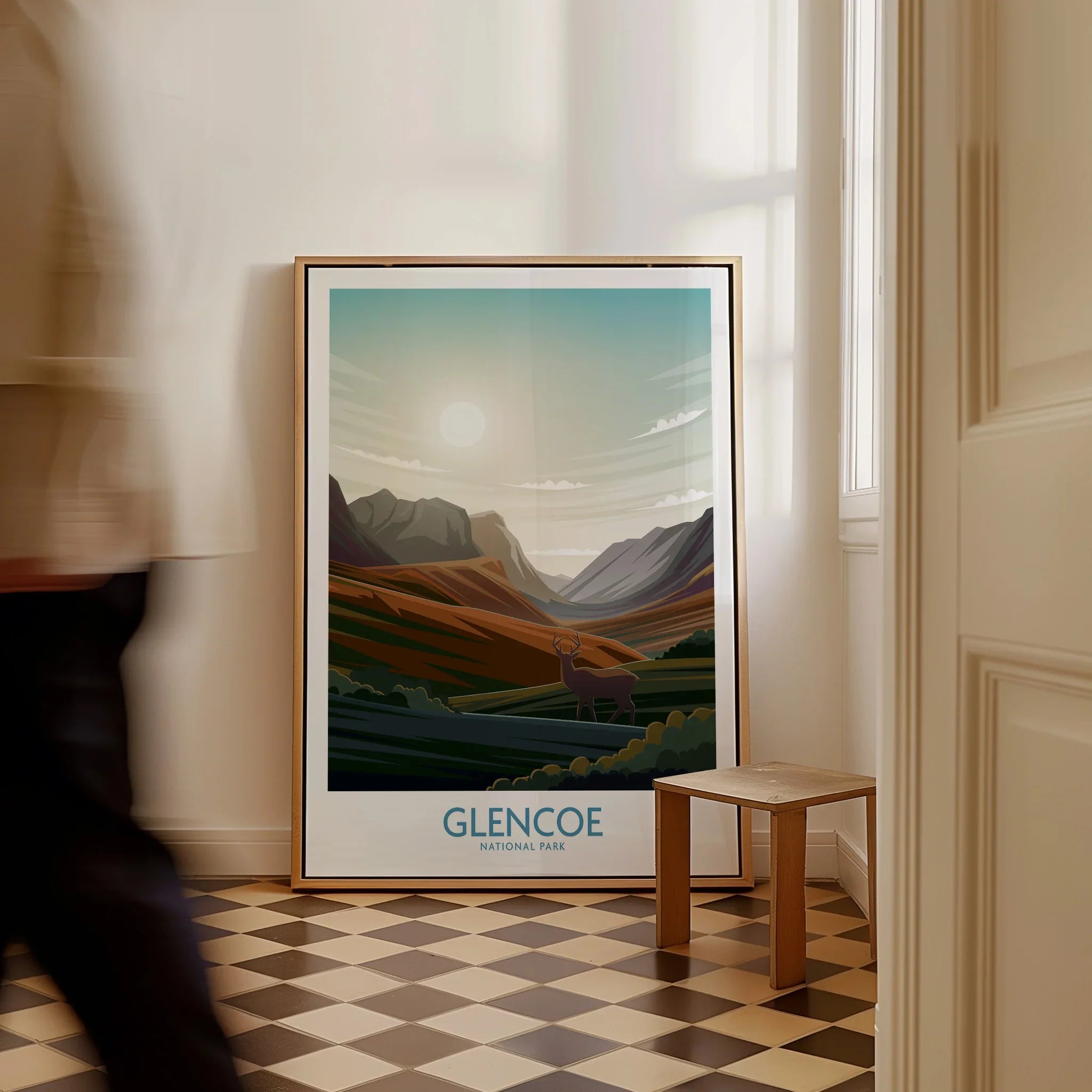 Framed Glencoe National Park travel poster with mountain landscape leaning on floor in hallway