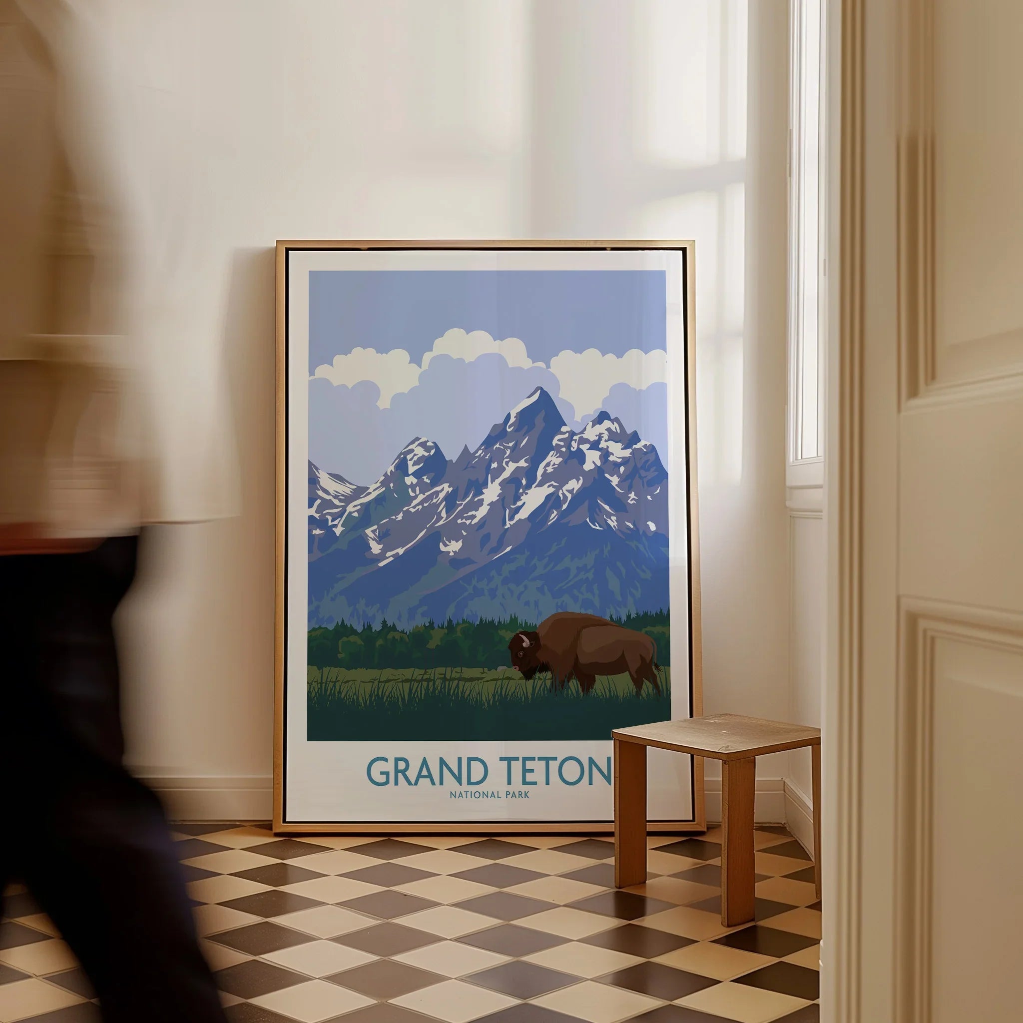 Framed Grand Teton National Park art print with bison and mountains on floor in hallway