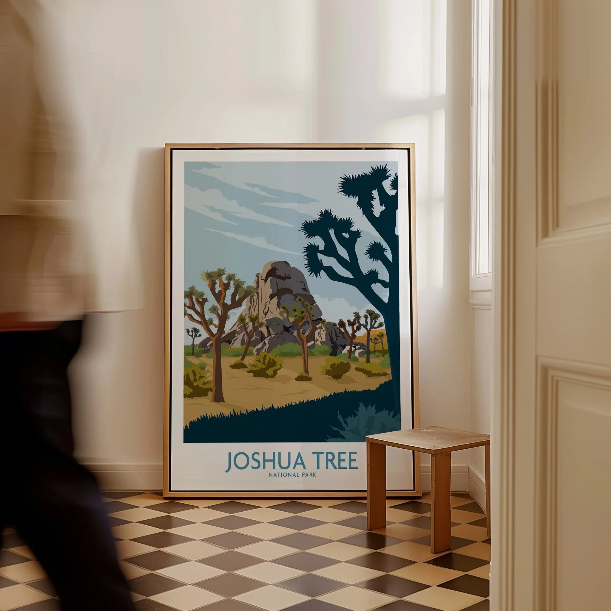 Framed Joshua Tree National Park art print leaning on floor, man walking past in hallway
