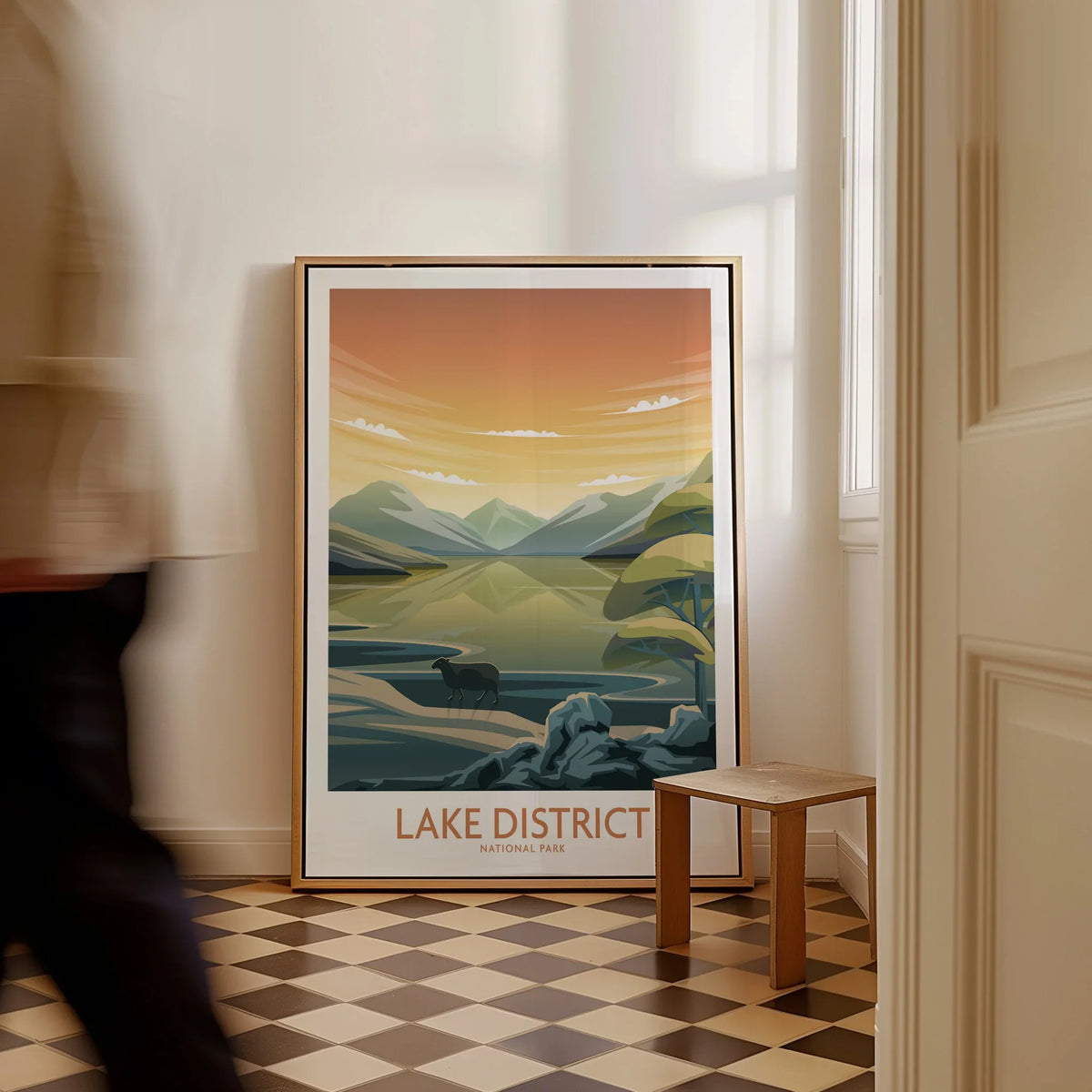 Framed Lake District National Park travel poster on floor in sunlit home entryway