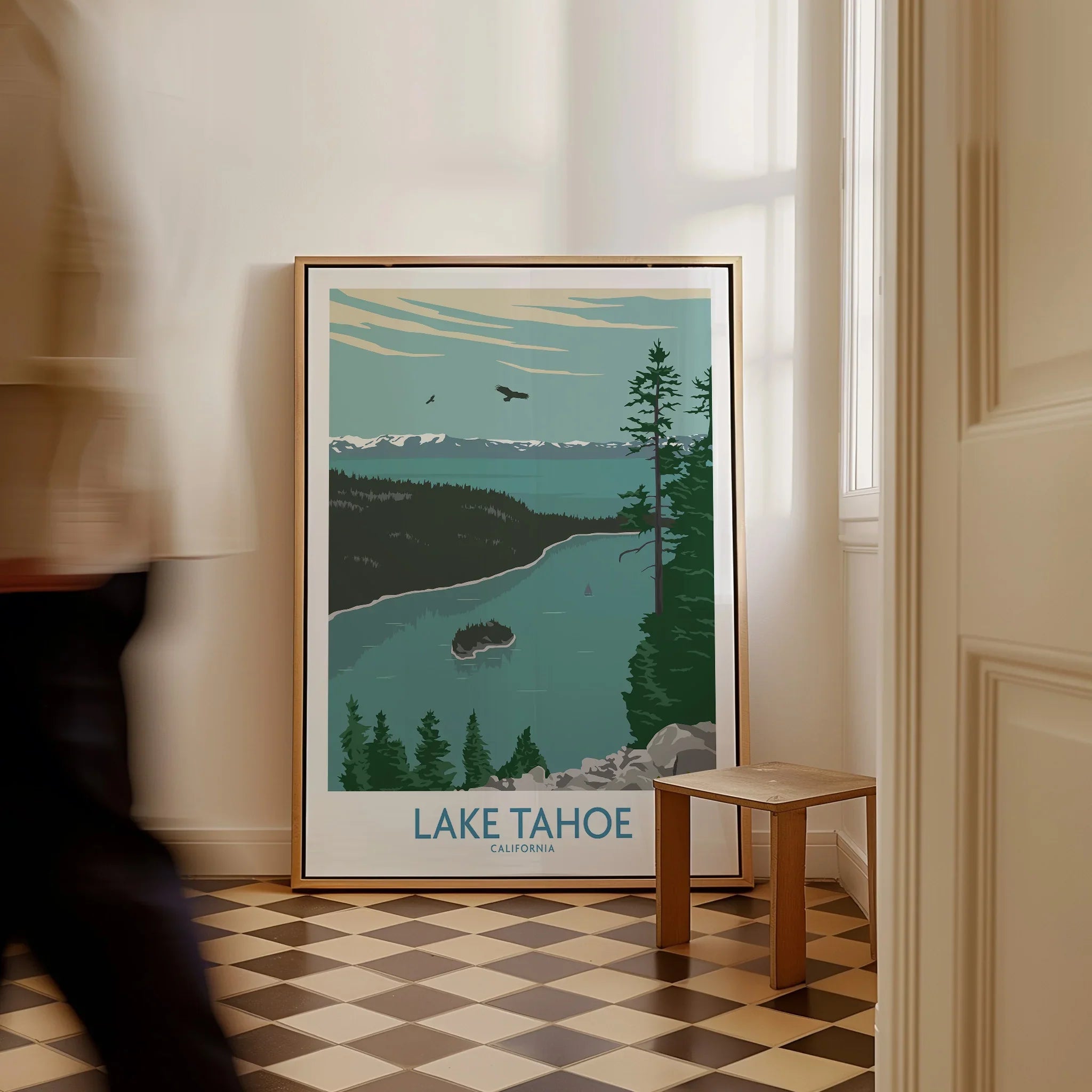 Lake Tahoe framed travel poster with nature art on floor in bright hallway