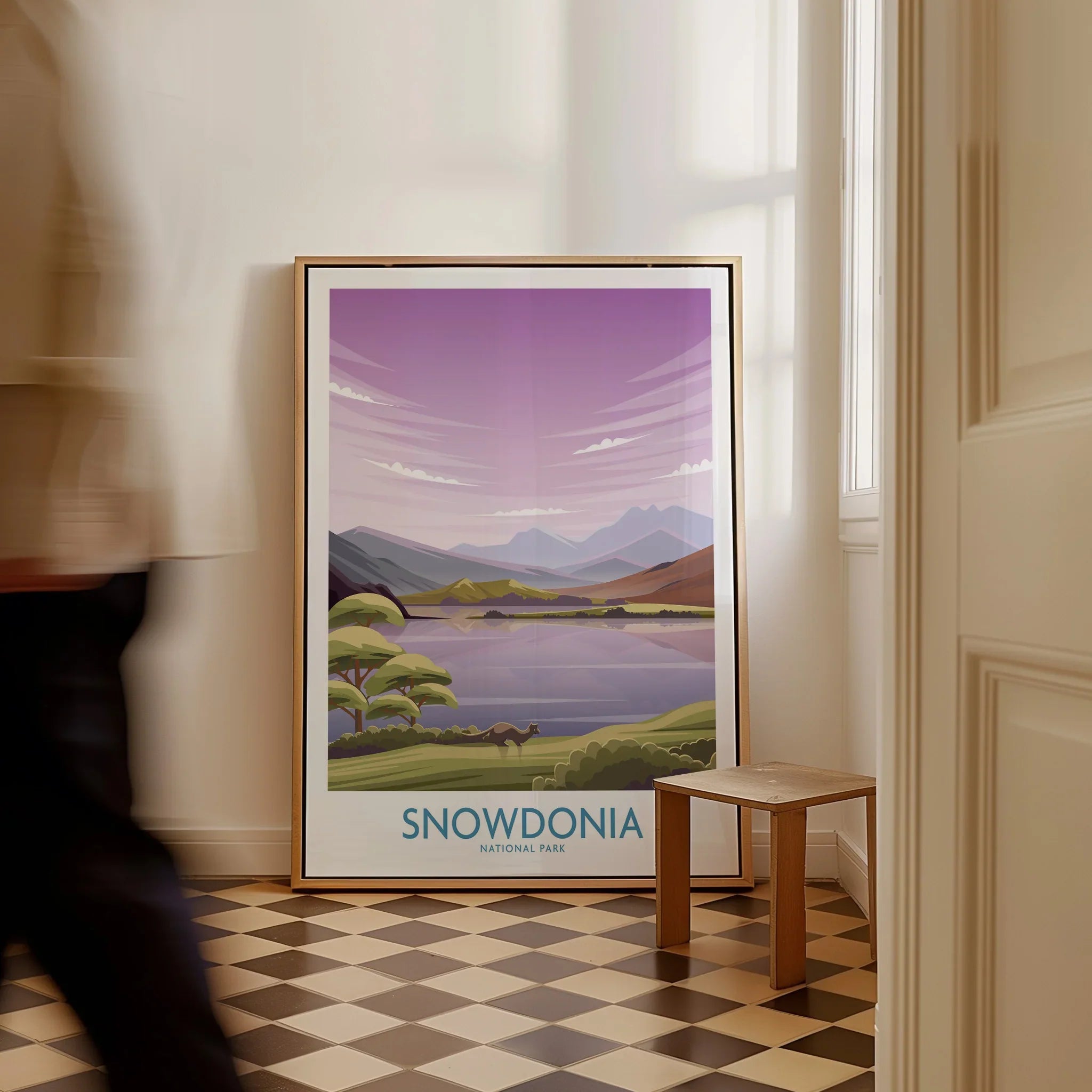 Framed Snowdonia National Park travel poster leaning on floor in bright entryway