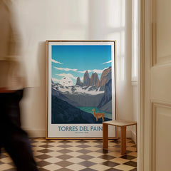 Framed Torres del Paine National Park travel poster on floor, man walking past in hallway