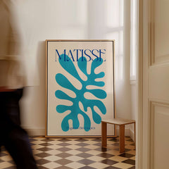 Matisse Cyan Blue Abstract Shape Papiers Découpés Poster displayed in a stylish interior with a checkered floor.