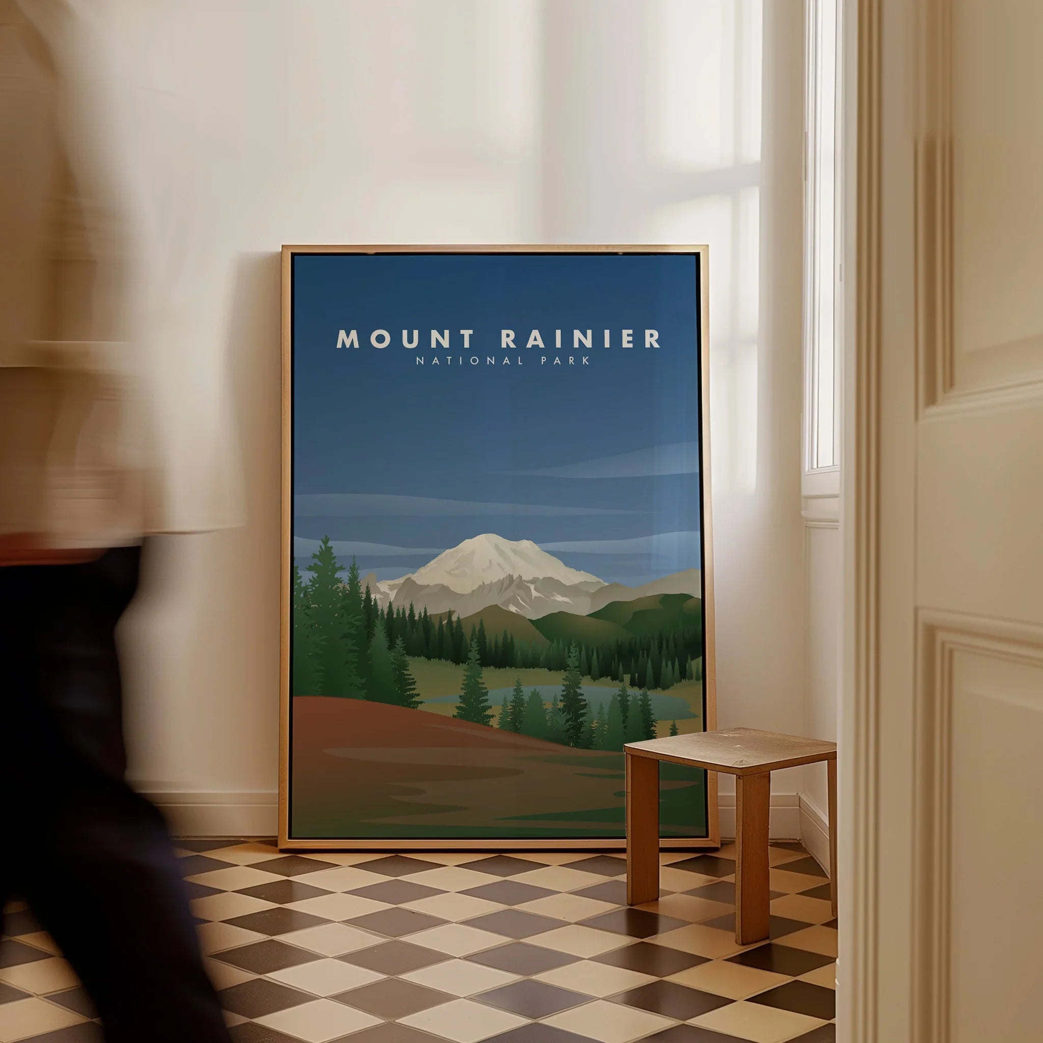 Framed Mount Rainier National Park travel poster on floor in bright modern hallway