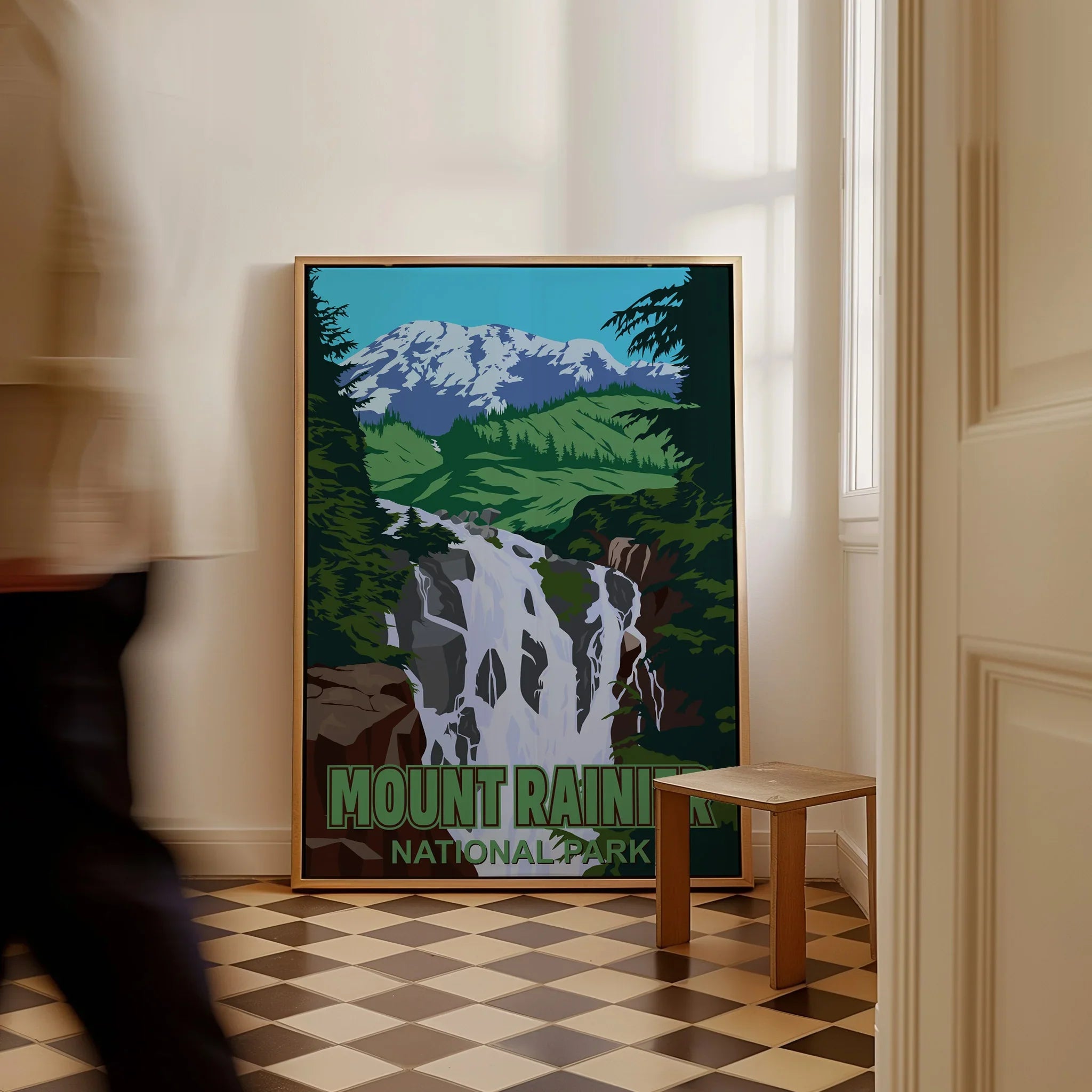 Framed Mount Rainier National Park travel poster with waterfall art on floor in hallway