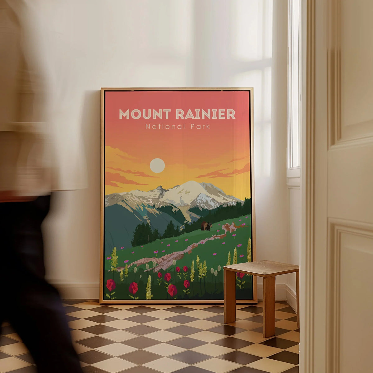 Framed Mount Rainier National Park travel poster with colorful landscape on floor, man walking by