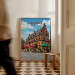 Framed Nijmegen Netherlands travel poster leaning on wall in modern home interior.