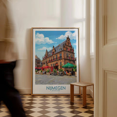 Framed Nijmegen Netherlands travel poster leaning on wall, man walking past in hallway