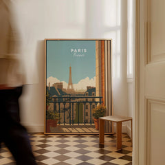 Framed Paris travel poster with Eiffel Tower on floor in sunlit hallway, man walking past