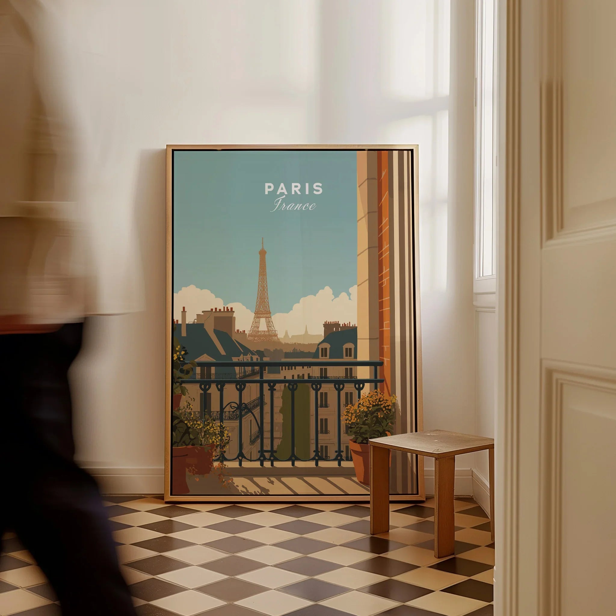 Framed Paris travel poster with Eiffel Tower on floor in sunlit hallway, man walking past