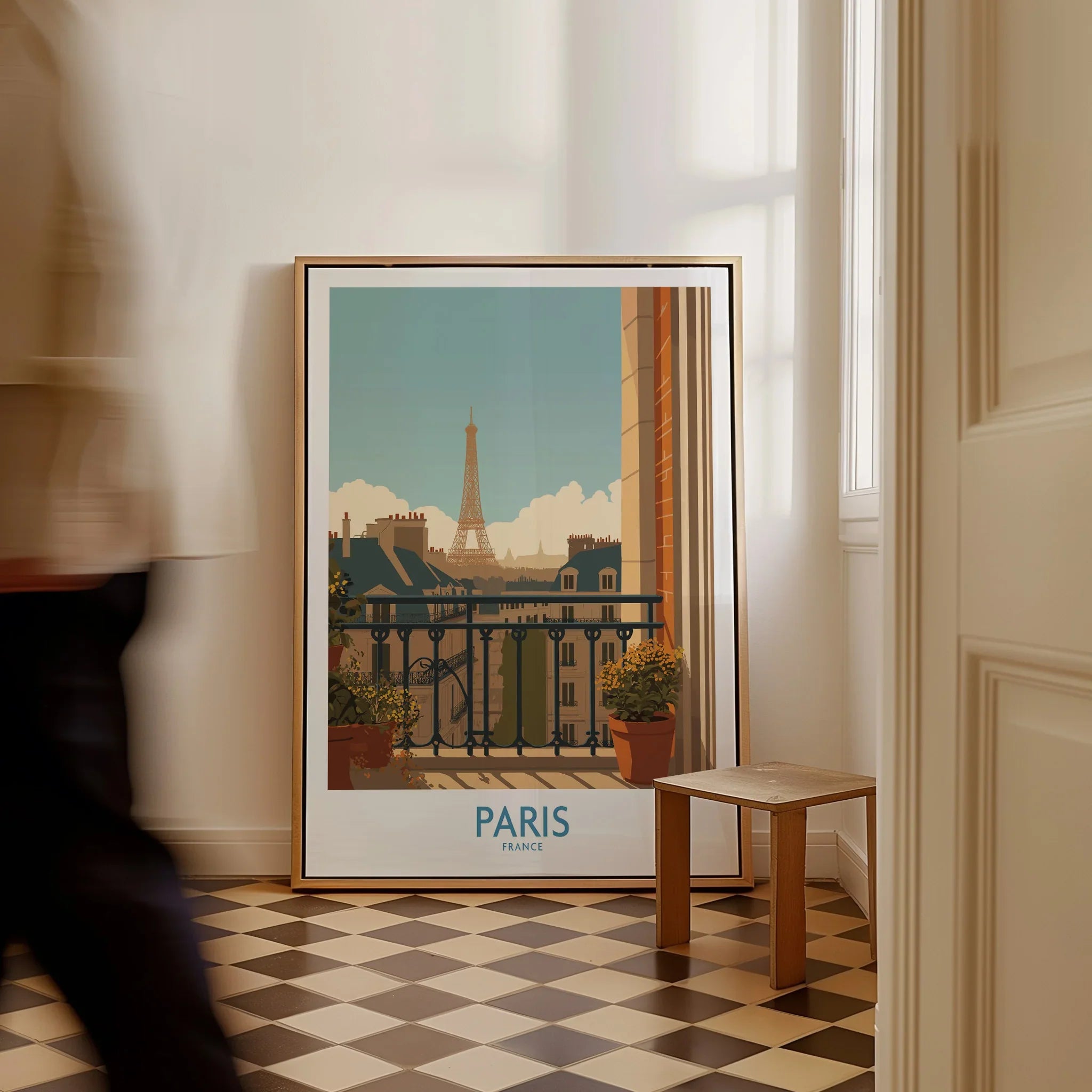 Framed Paris Eiffel Tower travel poster on floor in sunlit room, man walking past