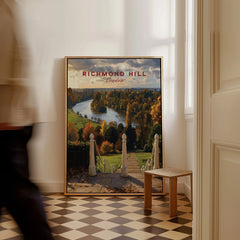 Richmond Hill London travel poster framed on the floor in a bright hallway with a person walking by.