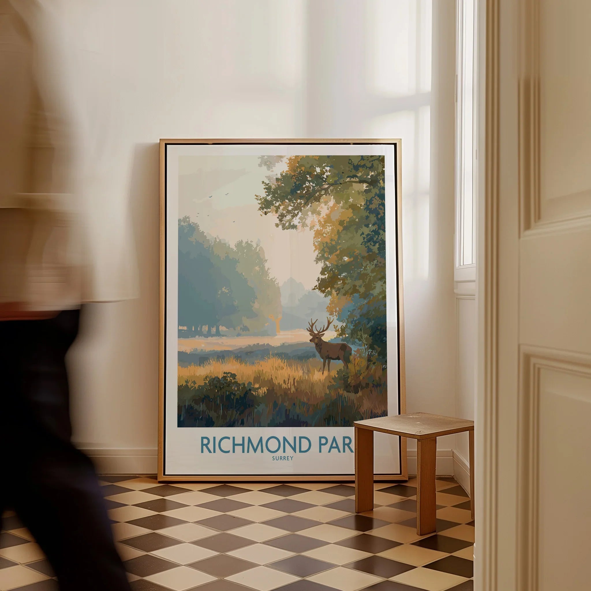 Framed Richmond Park art print leaning on wall, man walking by in modern hallway