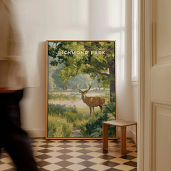 Framed Richmond Park travel poster with deer resting on floor in sunlit hallway