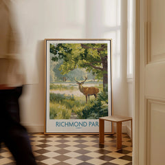 Framed Richmond Park travel poster with deer and trees on floor in bright hallway