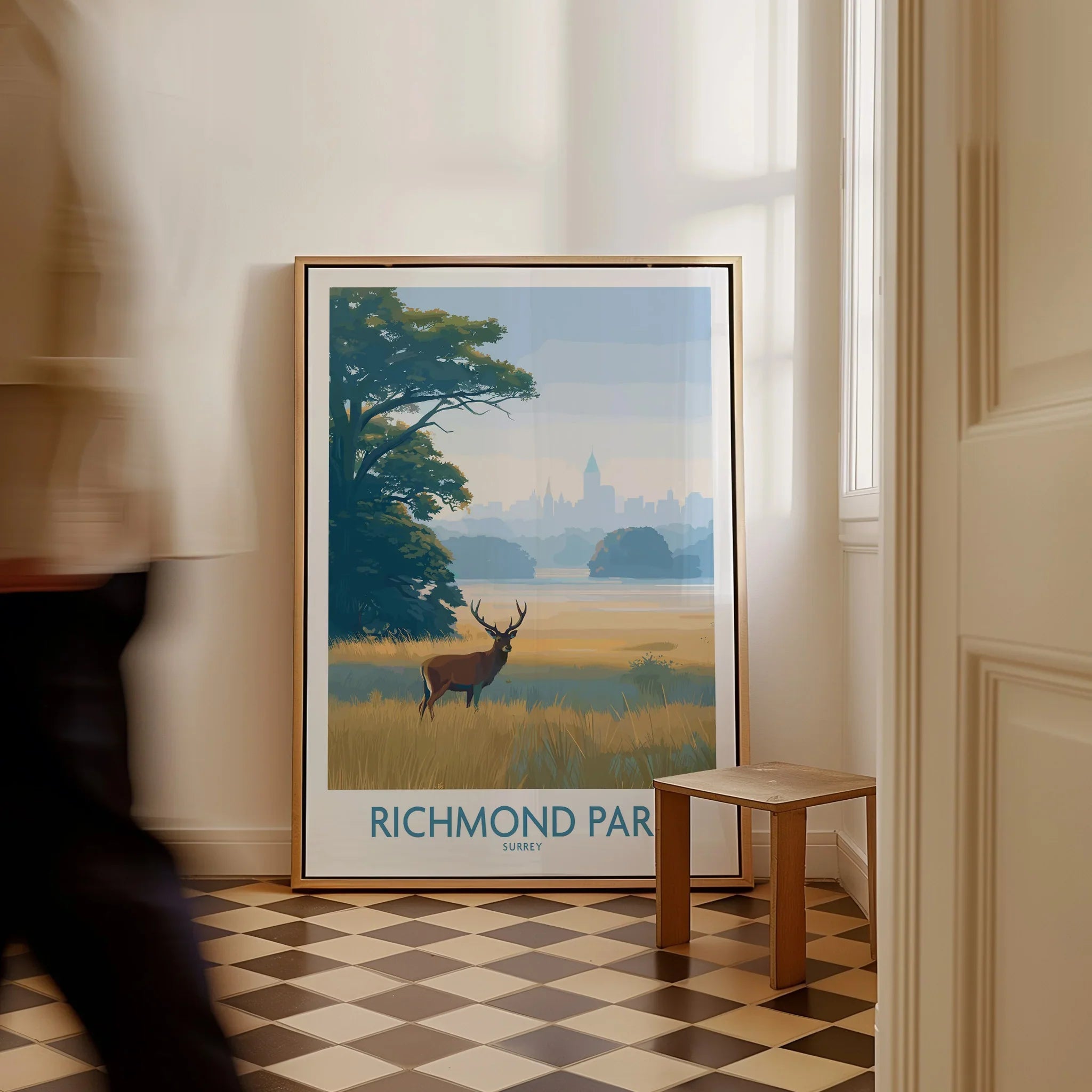 Framed Richmond Park art print with deer and landscape, leaning on floor in modern hallway