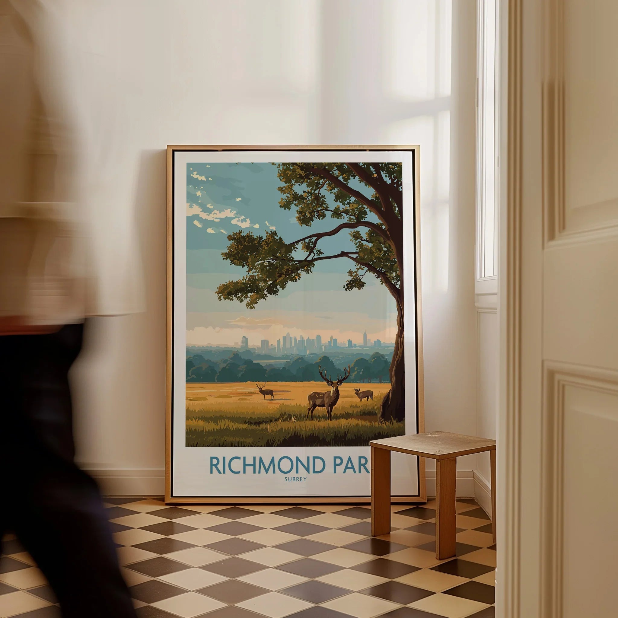 Framed Richmond Park travel poster with deer and tree on floor in bright hallway