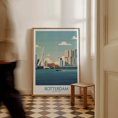 Rotterdam city skyline framed travel poster on floor, modern hallway decor, man walking past