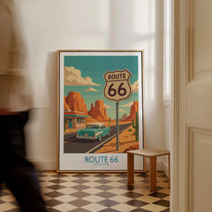 Framed Route 66 travel poster with vintage car and desert highway, leaning on a floor.