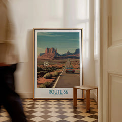 Framed Route 66 travel poster with desert landscape on floor in modern hallway
