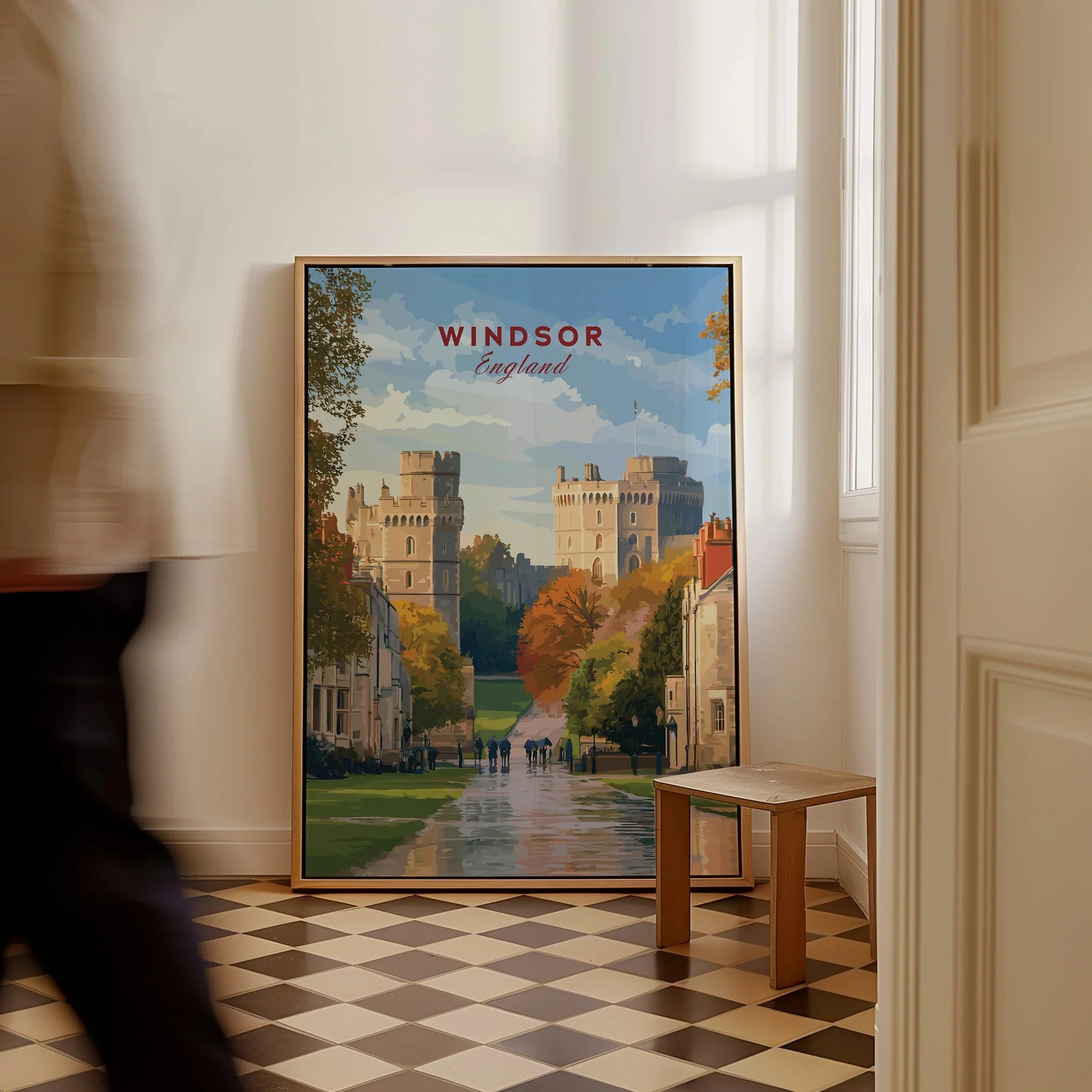 Framed Windsor England travel poster with castle art leaning on floor, man walking past