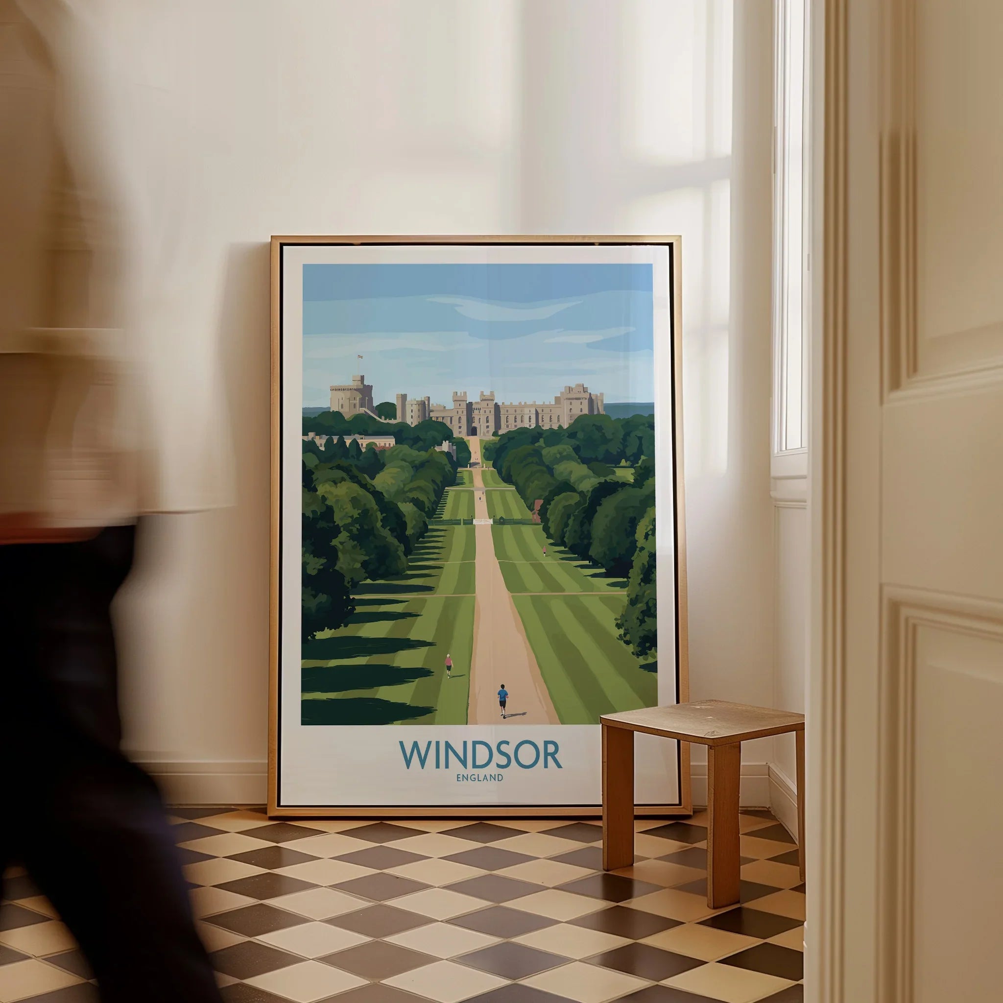 Framed Windsor England travel poster on floor, man walking past in bright room