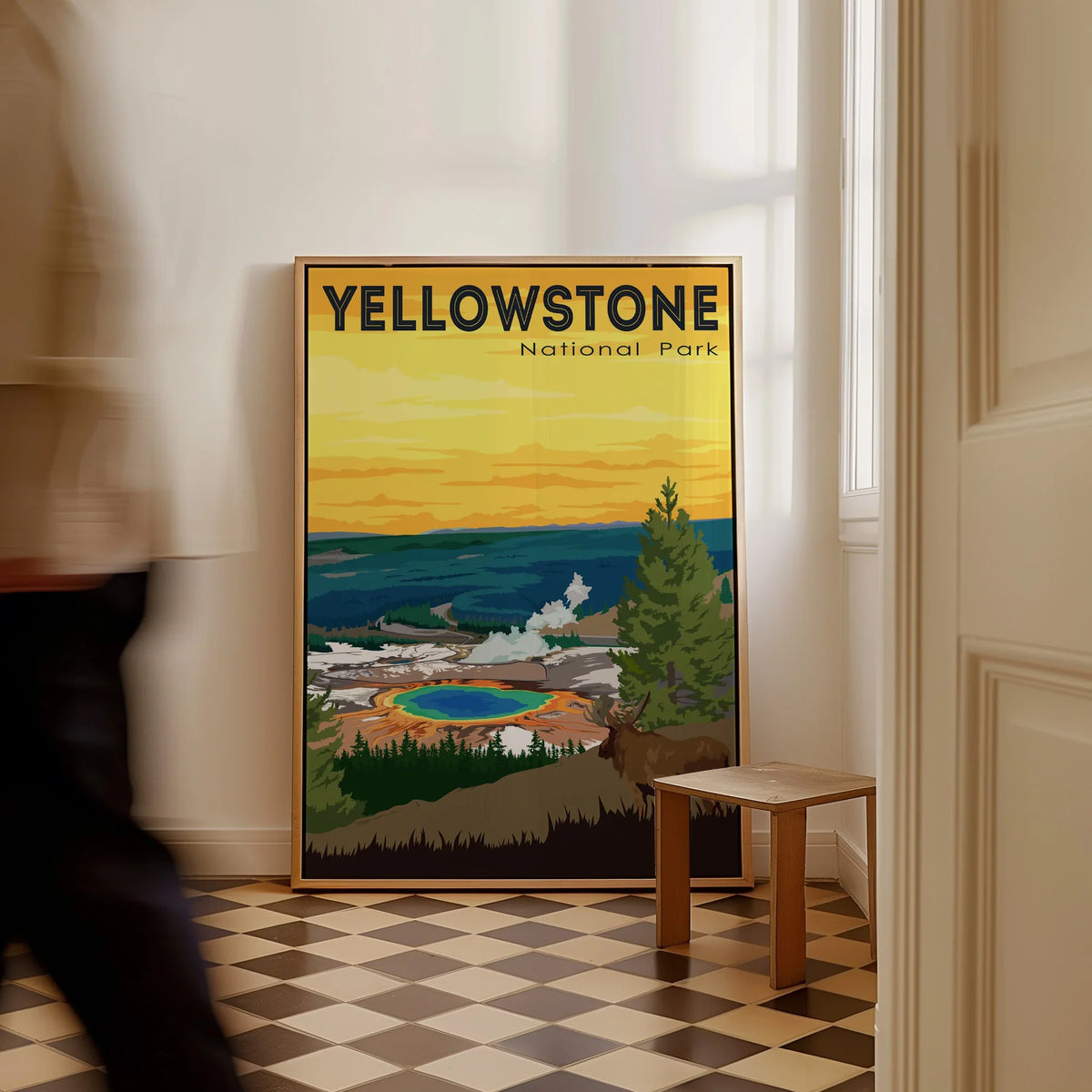 Framed Yellowstone National Park poster with colorful landscape on floor in bright hallway